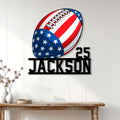 Patriotic football metal wall sign displayed on a light wood-paneled wall above a console table
