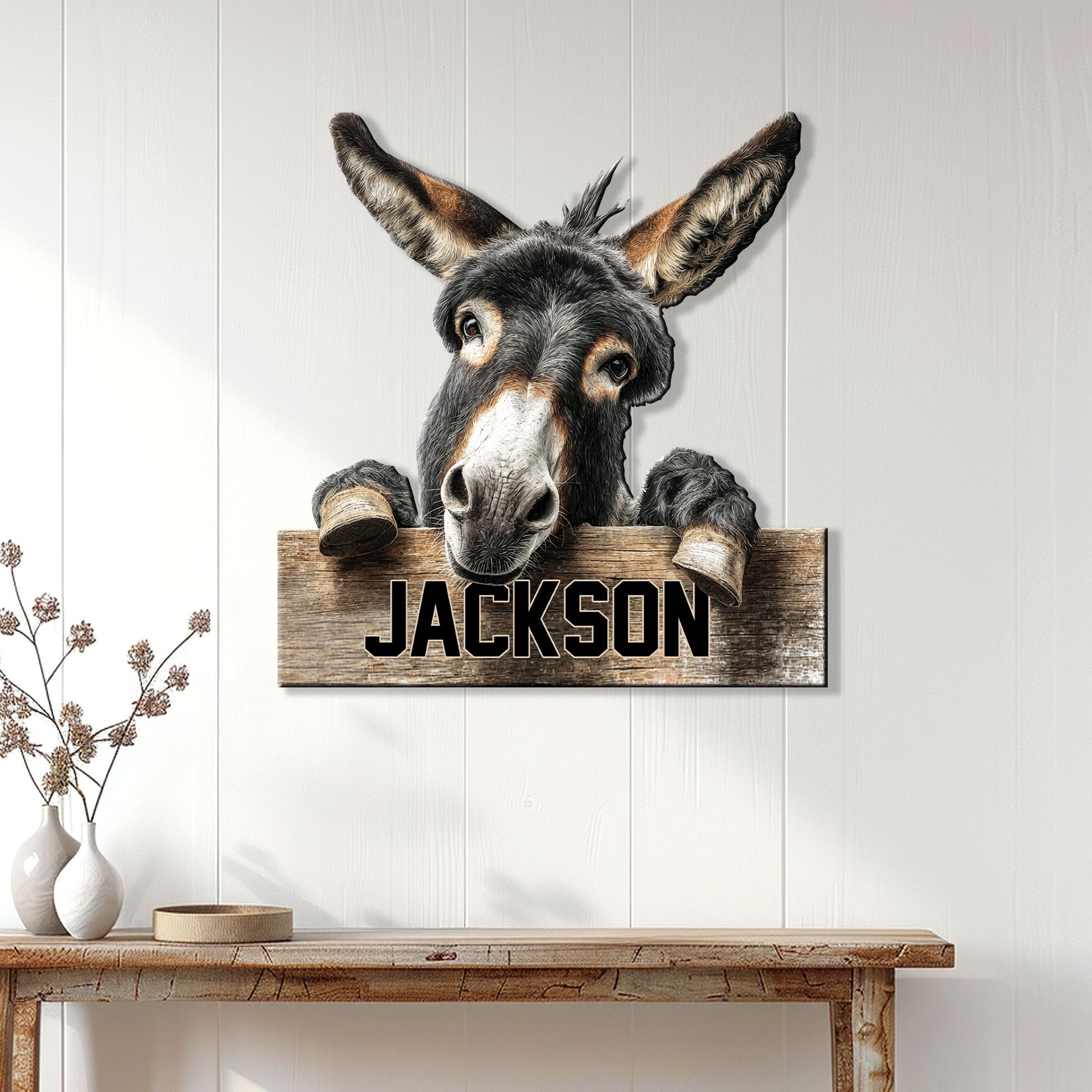 Rustic donkey metal sign displayed on a white paneled wall above a wooden console table
