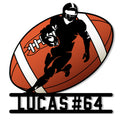 Football player silhouette carrying a ball across an orange football on a custom metal wall sign