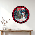 Round snowman Christmas sign displayed as seasonal wall decor above a wood console table