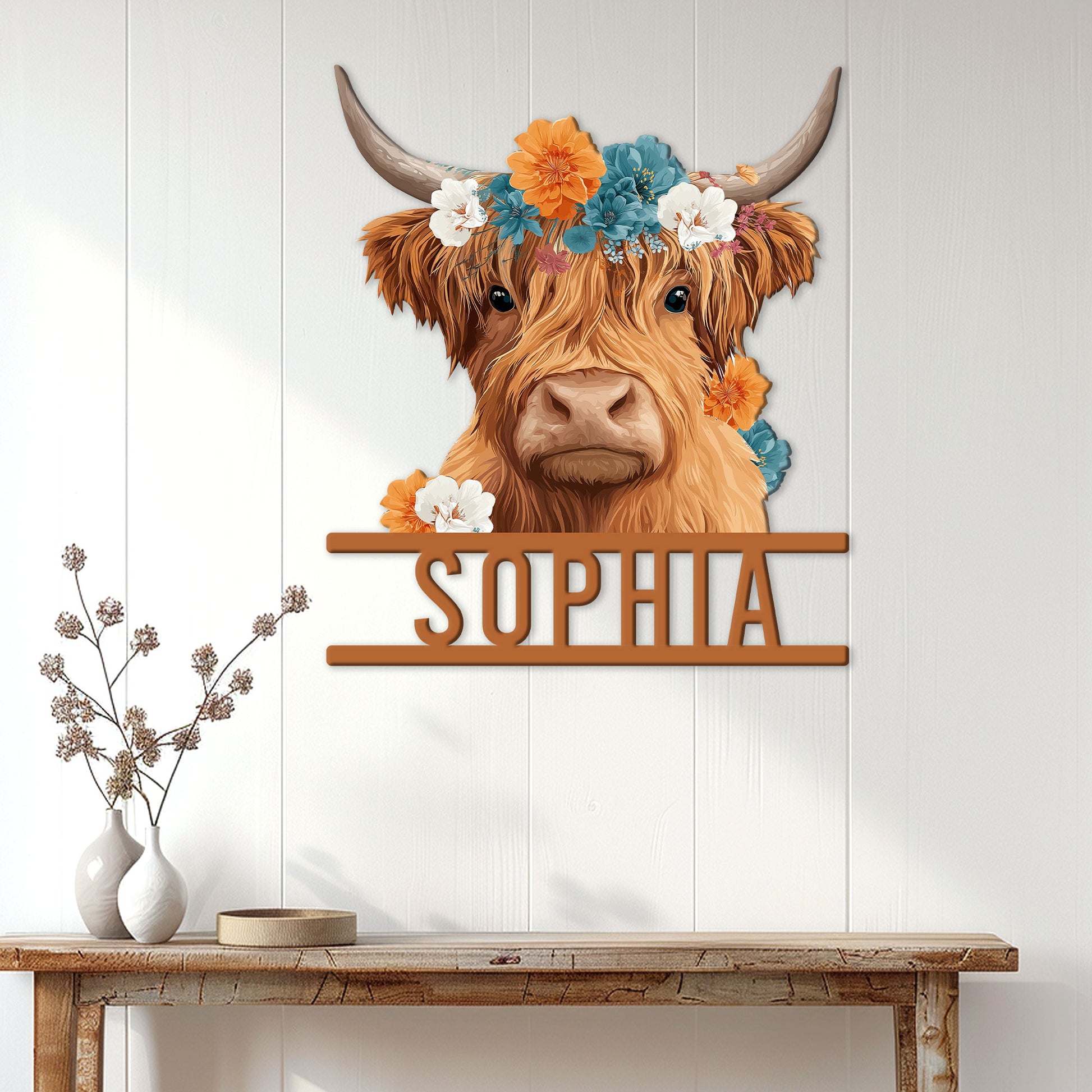 Highland cow metal sign displayed on a white paneled wall above a rustic console table