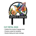 Cut metal hummingbird garden sign featuring a vibrant bird, floral design, and decorative garden stake