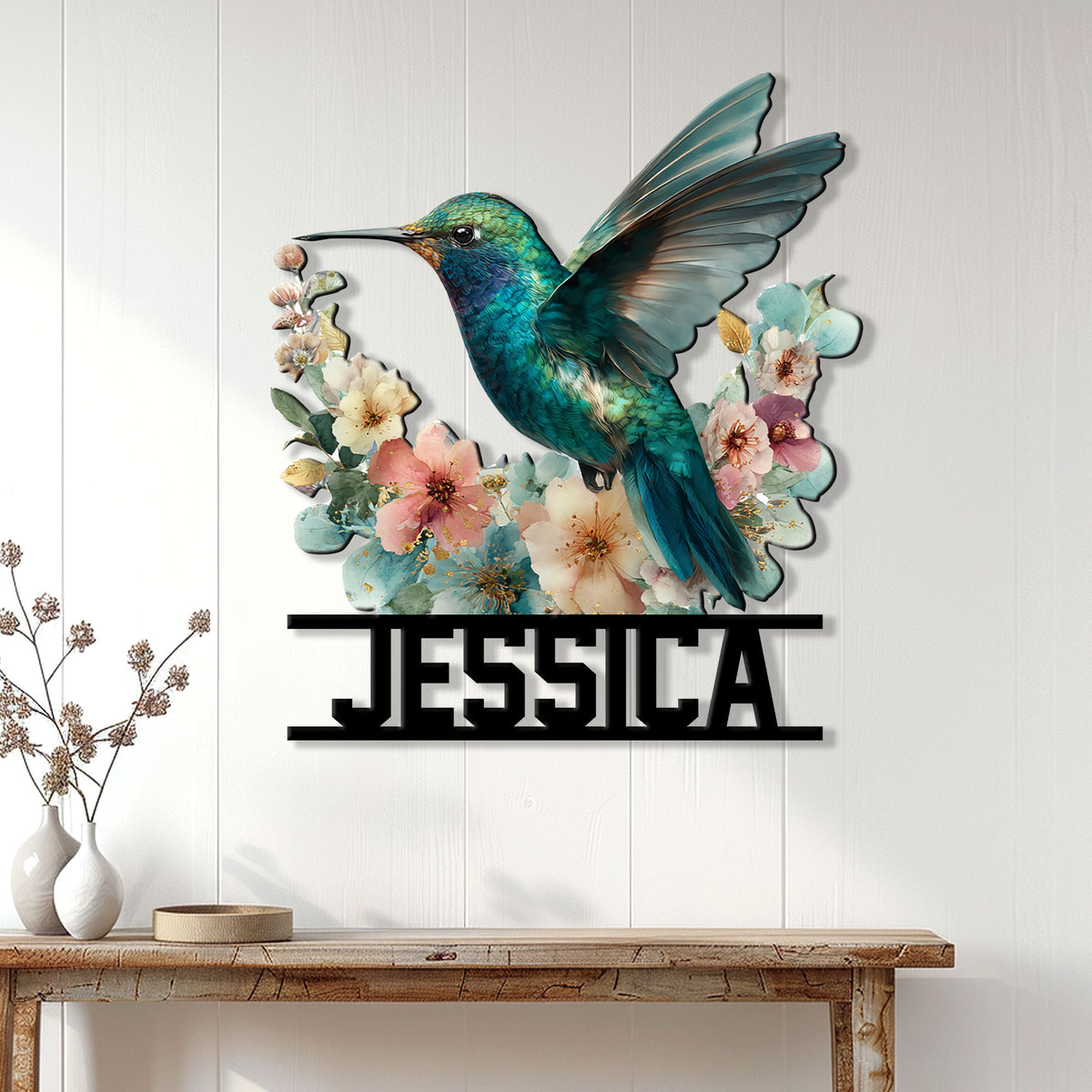 Hummingbird wall sign displayed on a light paneled wall above a console table with floral home decor