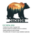 Bear metal sign with a layered forest and mountain sunset design, shown as a cut metal wall accent