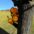 Orange and black gorilla sign shown outdoors beside a large tree in a sunny field
