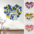 Cheerleading metal sign displayed on a wall with colorful pom poms and multiple design color options