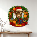 Christmas goat wall sign displayed on a white paneled wall above a console table in a bright home