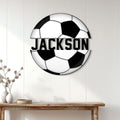 Soccer ball metal sign displayed on a white paneled wall above a wooden console table