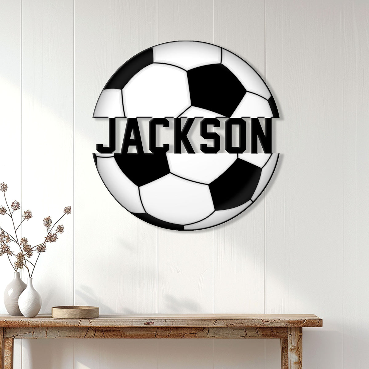 Soccer ball metal sign displayed on a white paneled wall above a wooden console table