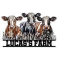 Colorful cut metal sign featuring three cows standing in tall grass with a bold farm-themed base