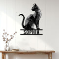 Low-poly black cat wall sign displayed above a console table in a bright modern entryway