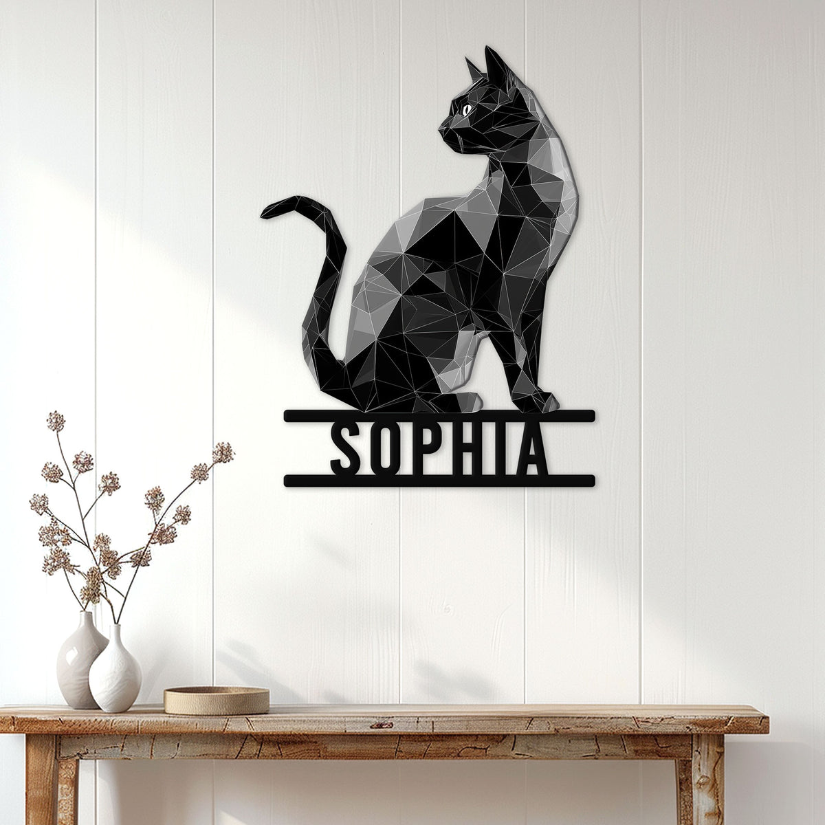 Low-poly black cat wall sign displayed above a console table in a bright modern entryway