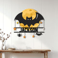 Halloween bat wall sign displayed on a white paneled wall above a console table