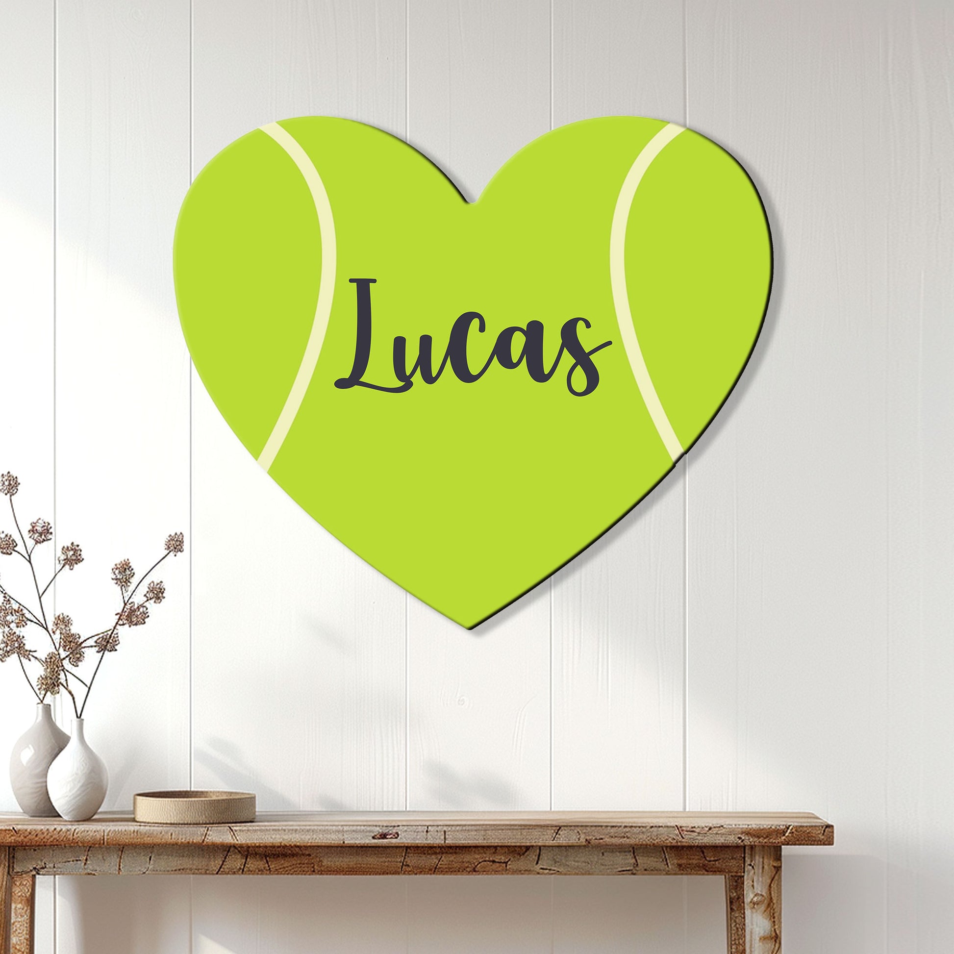 Heart-shaped tennis ball sign displayed as colorful wall decor in a bright home interior