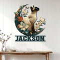 Floral Siamese cat metal wall sign displayed above a console table in a bright room