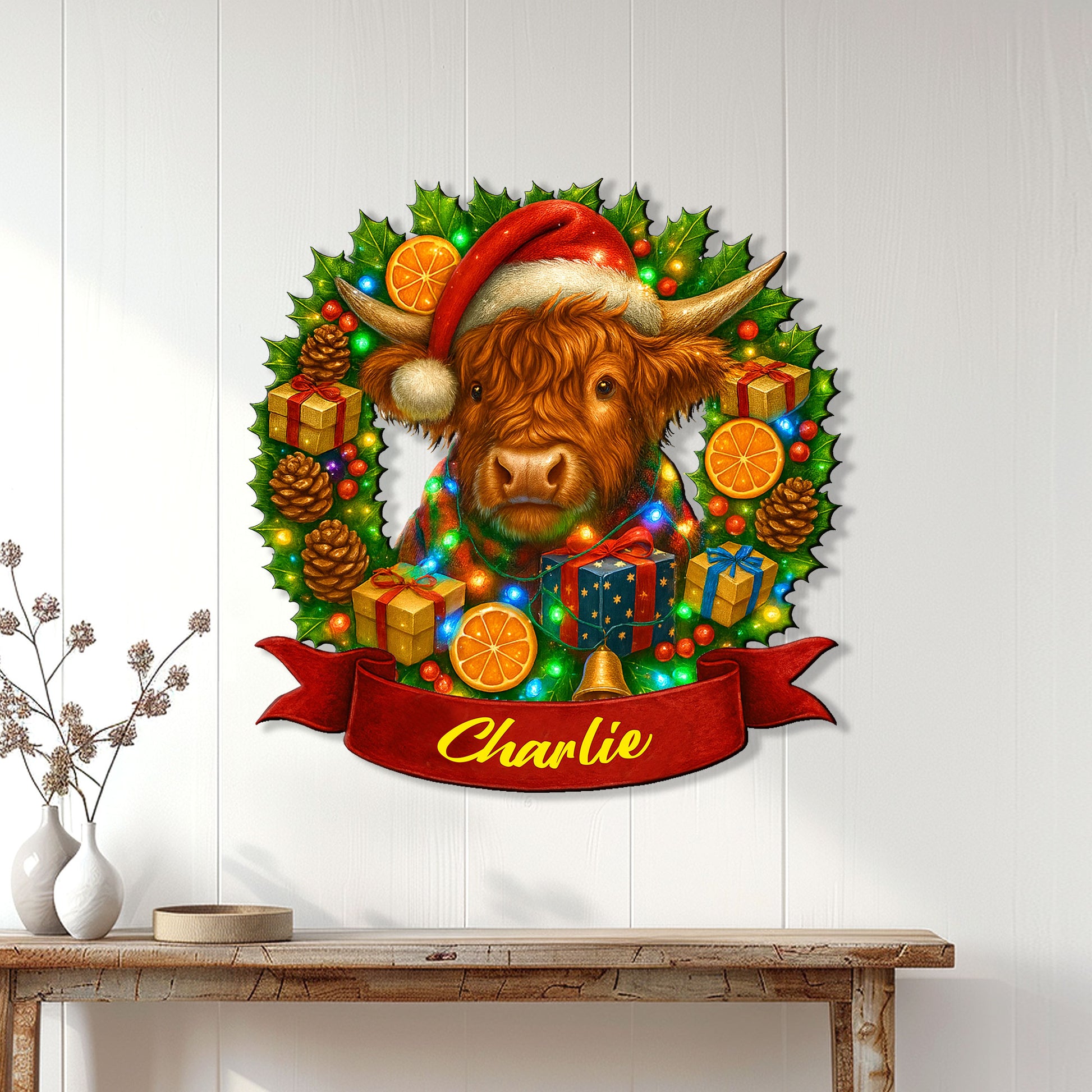 Festive Highland cow wall sign displayed on a white paneled wall above a wooden console table
