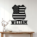 American flag police badge metal sign displayed on a white paneled wall above a console table