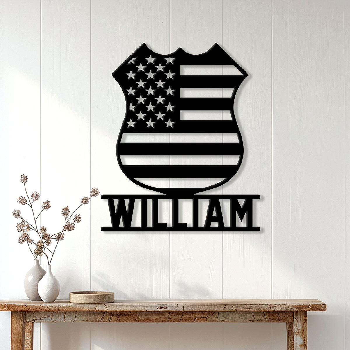 American flag police badge metal sign displayed on a white paneled wall above a console table