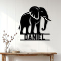 Black elephant metal wall sign displayed on a bright paneled wall above a console table