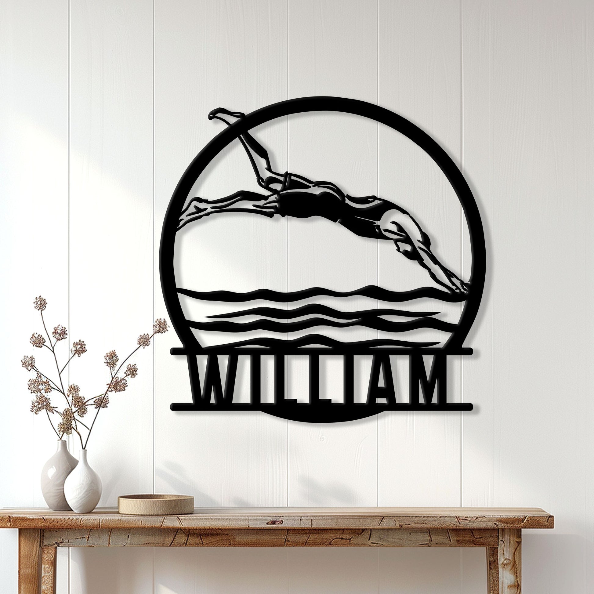 Swimmer metal wall decor displayed on a light paneled wall above a wood console table