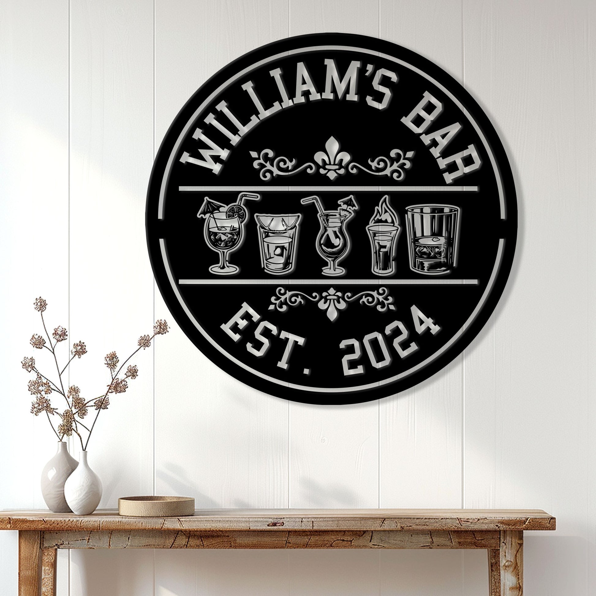 Round cocktail bar sign displayed on a white paneled wall above a rustic console table
