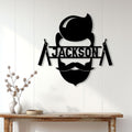 Black barber shop metal wall sign displayed on a white paneled wall above a wood console
