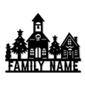 Black Christmas village metal sign featuring a church, snowy cottages, evergreen trees, stars, and a snowman silhouette