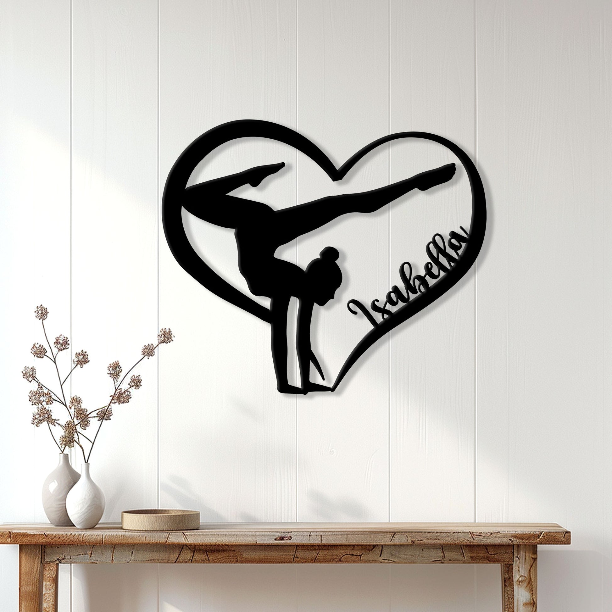 Heart-shaped gymnast metal wall sign displayed on a light paneled wall above a wooden console
