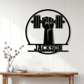 Black weightlifting metal sign displayed on a white wall above a console table