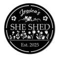 Round black She Shed metal sign with floral garden artwork and a decorative border