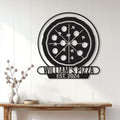 Pizza shop metal sign displayed on a white paneled wall above a rustic console table