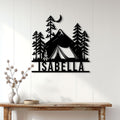 Black camping wall sign displayed on a white paneled wall above a rustic console table