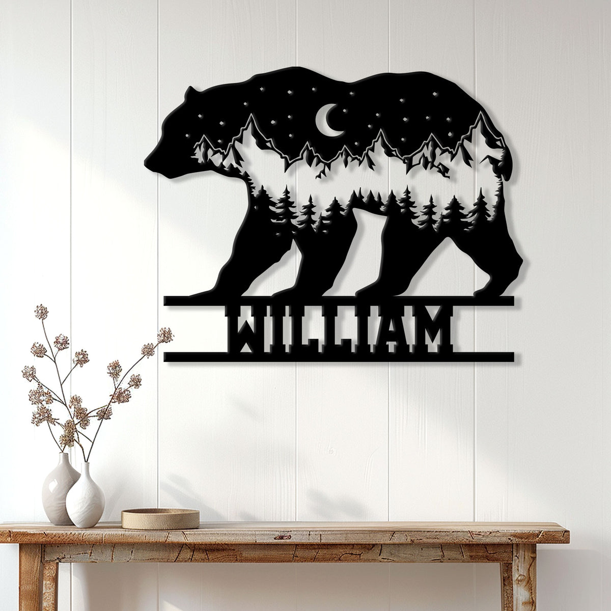 Bear silhouette metal wall sign displayed on a white wood-paneled wall above a console table