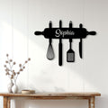 Black rolling pin kitchen wall decor displayed on a bright white paneled wall