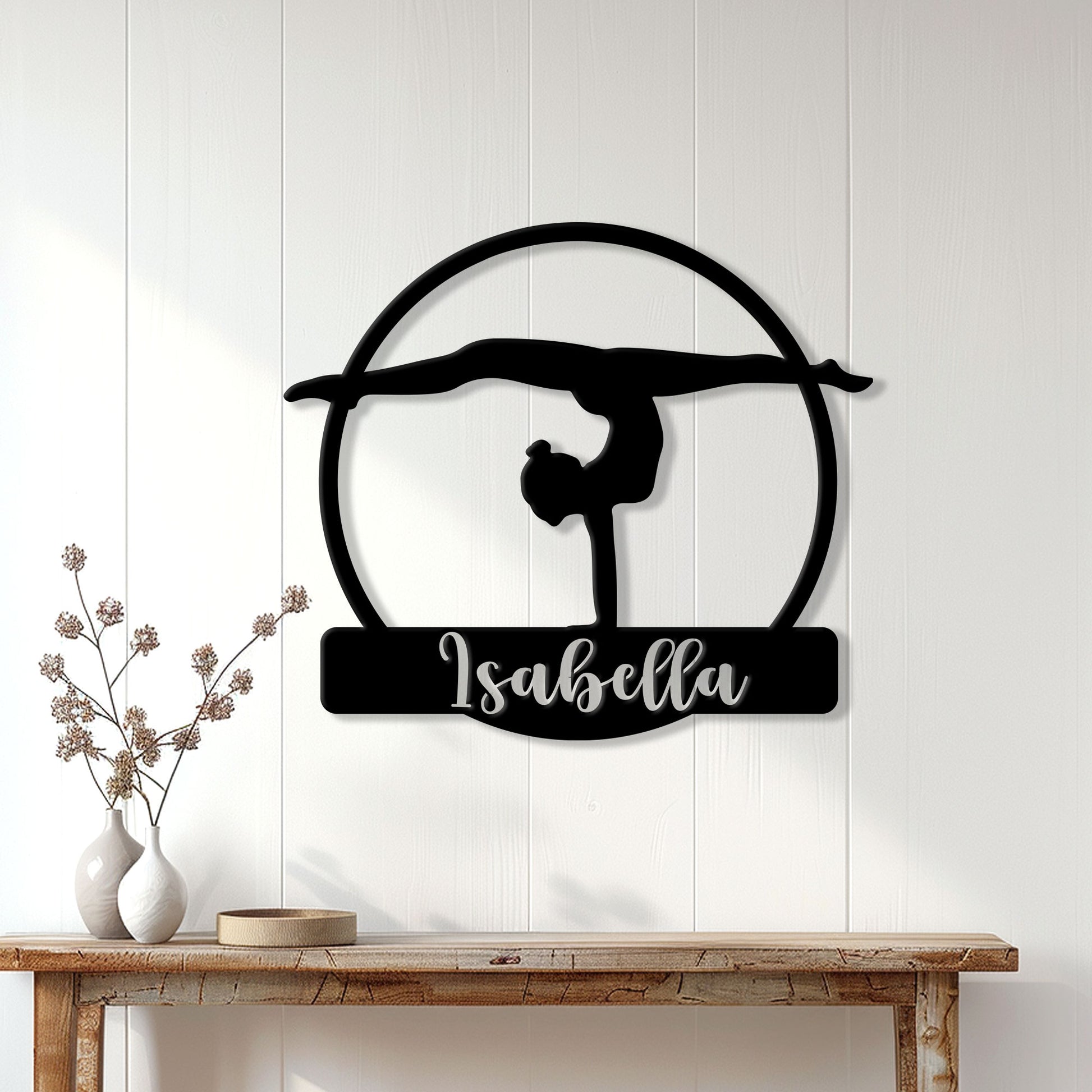 Gymnastics wall decor displayed on a white paneled wall above a console table in a bright home