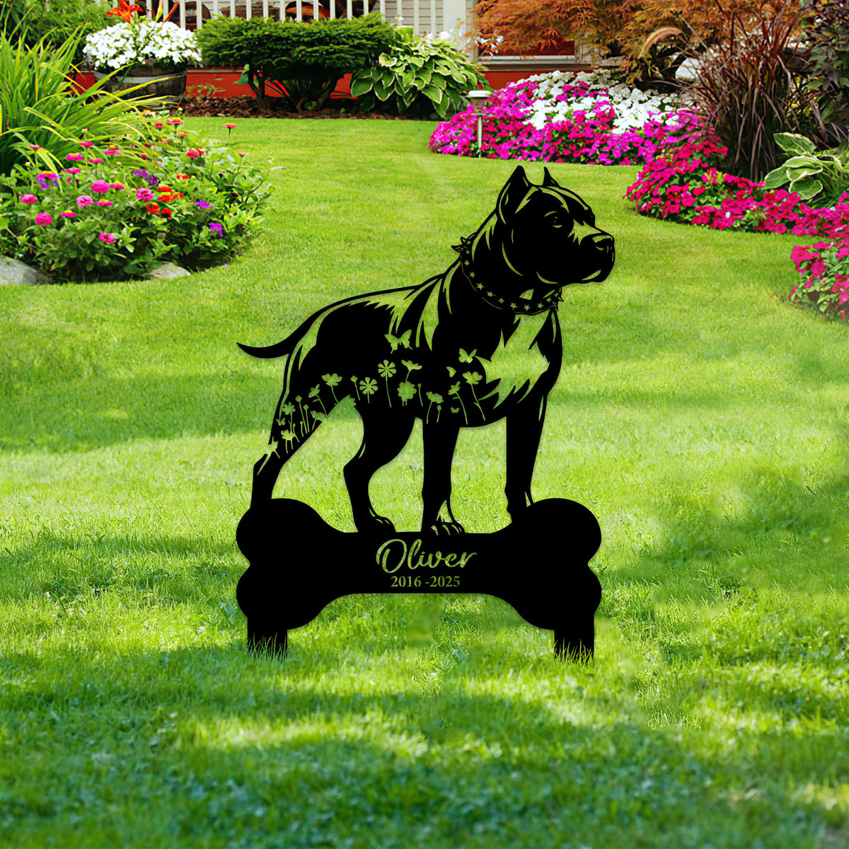 Pitbull memorial yard sign displayed in a landscaped garden, featuring a floral dog silhouette and bone design