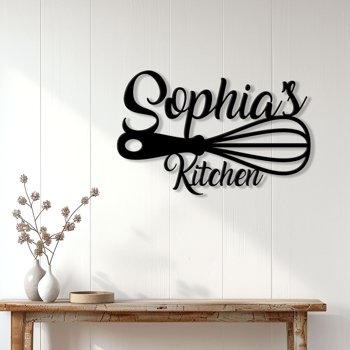 Black kitchen scissors wall sign displayed on white paneling above a rustic console table