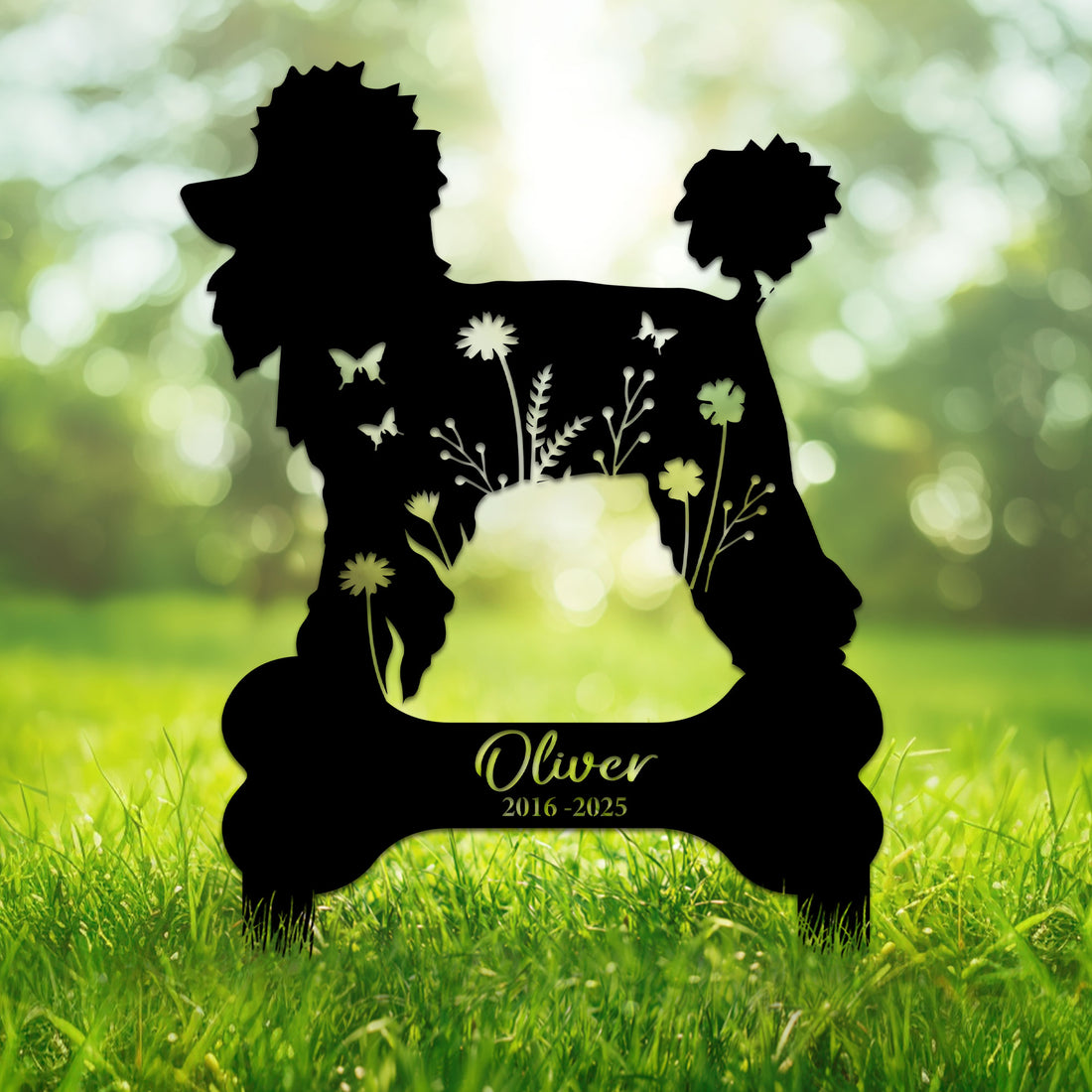 Poodle silhouette metal memorial sign with flowers and butterflies displayed in a garden setting