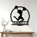 Cheerleader silhouette metal wall sign displayed on a light wood wall above a console table