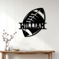 Black football wall sign displayed on white wood paneling above a rustic console table