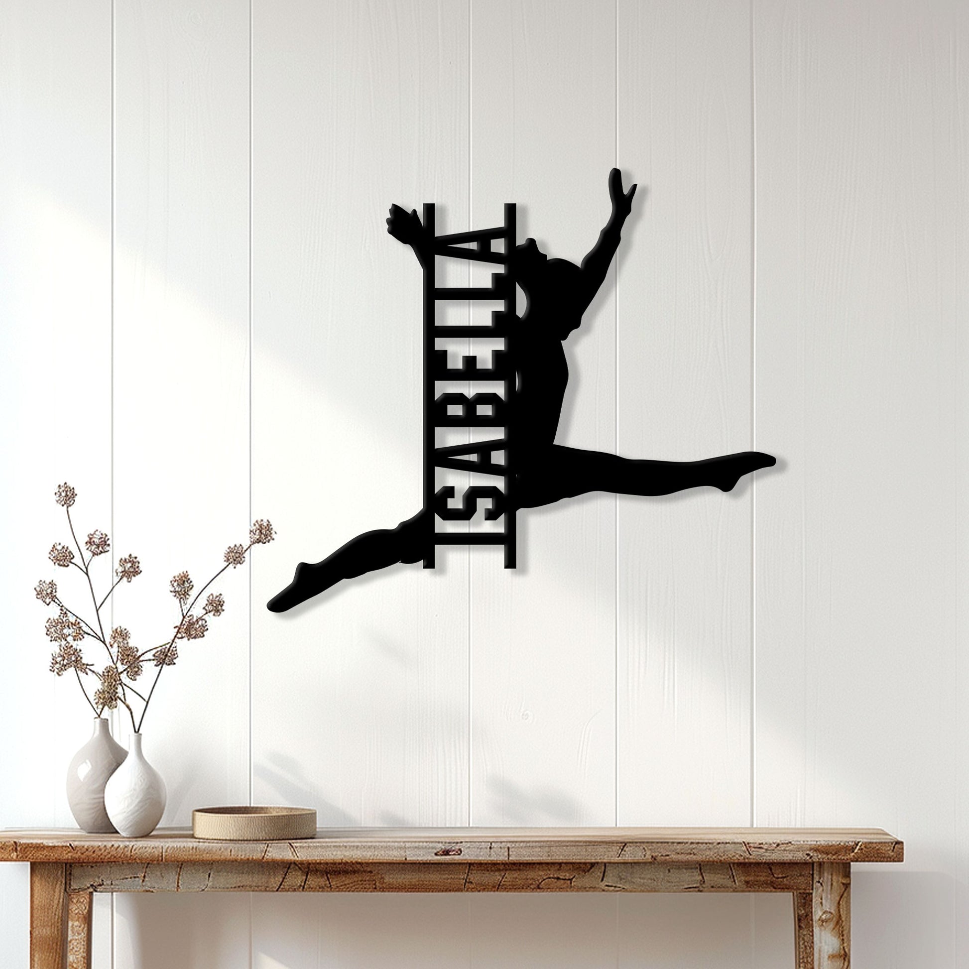 Black gymnastics wall sign displayed on a bright paneled wall above a rustic console table