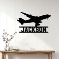 Black aircraft silhouette wall sign displayed as aviation decor above a modern console table