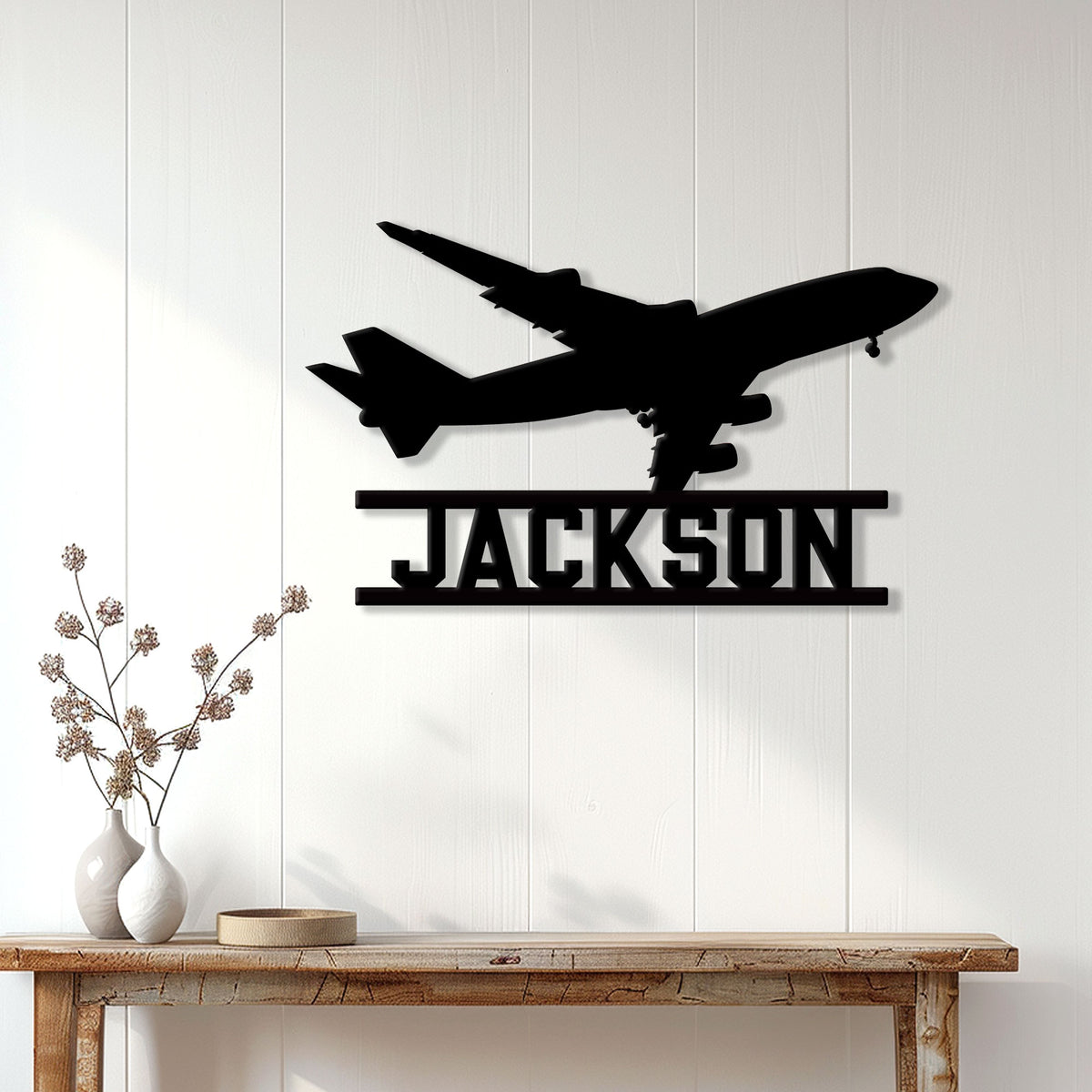 Black aircraft silhouette wall sign displayed as aviation decor above a modern console table