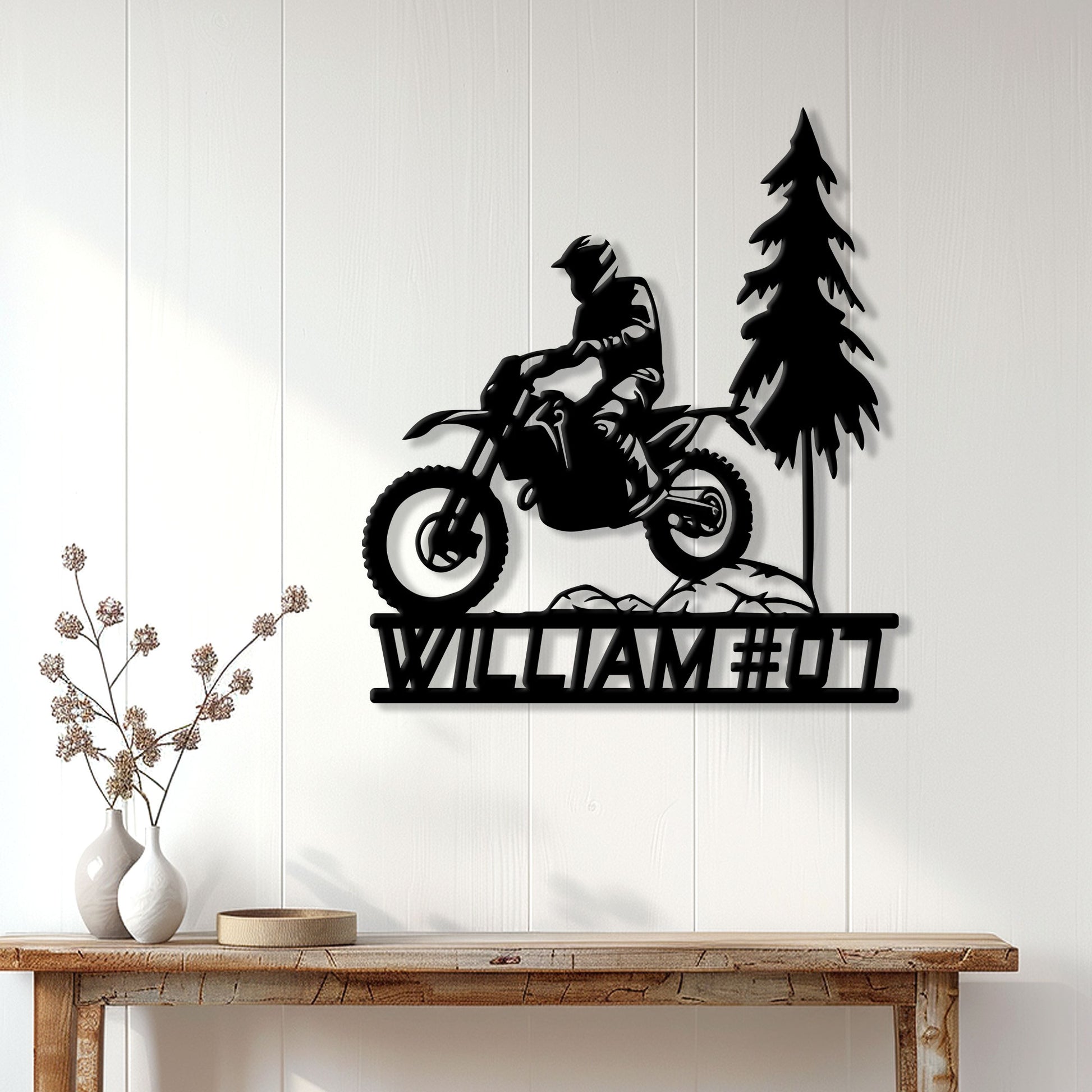 Motocross metal wall sign displayed on a light paneled wall above a rustic console table
