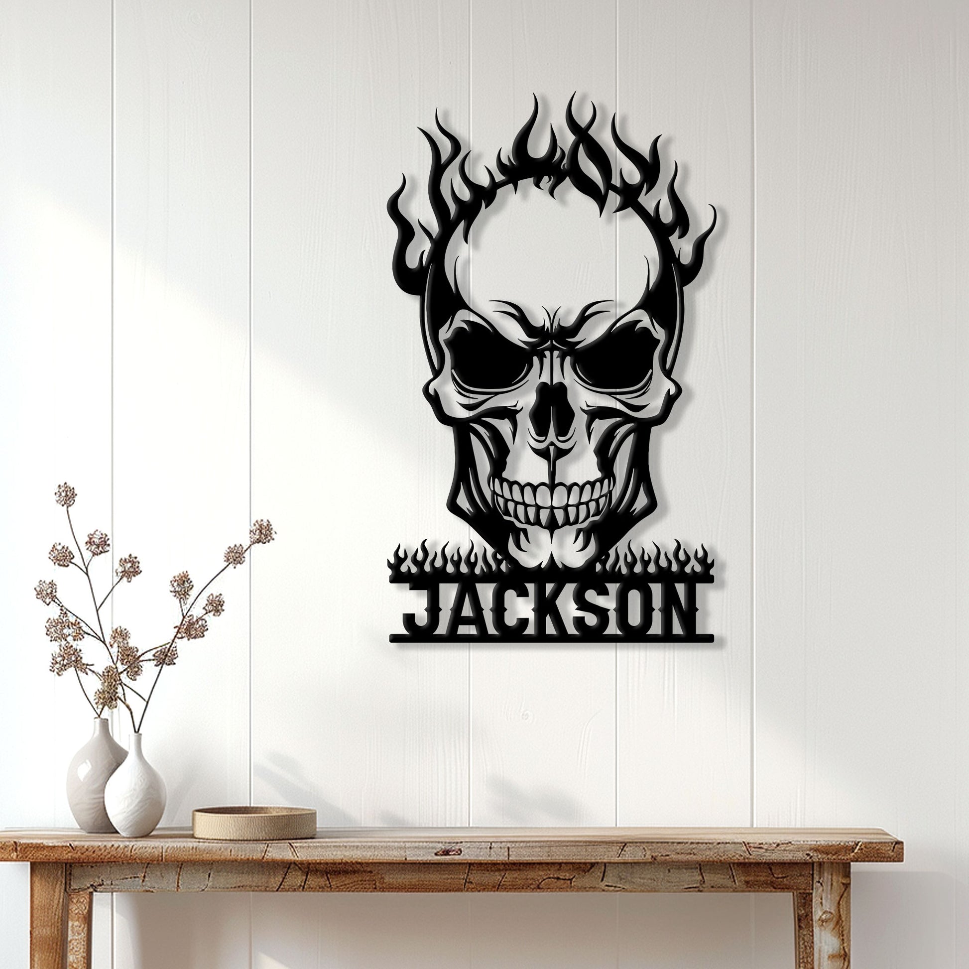 Flaming skull metal wall sign displayed on a white paneled wall above a wooden console