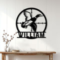 Duck hunter wall decor displayed on a white paneled wall above a rustic console table