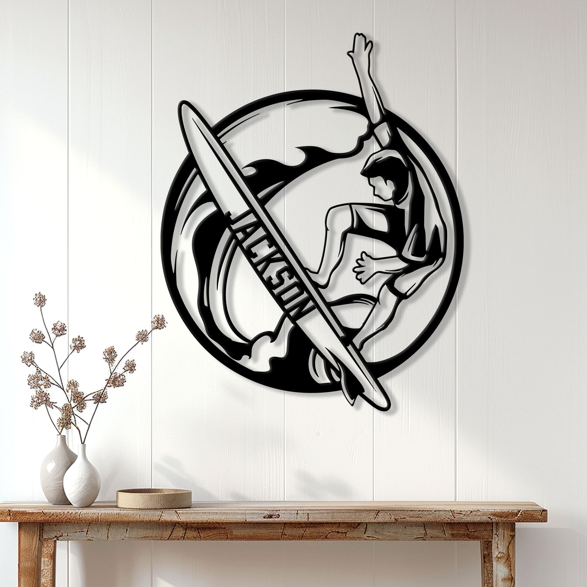 Surfer wall decor displayed on a white paneled wall above a wooden console table