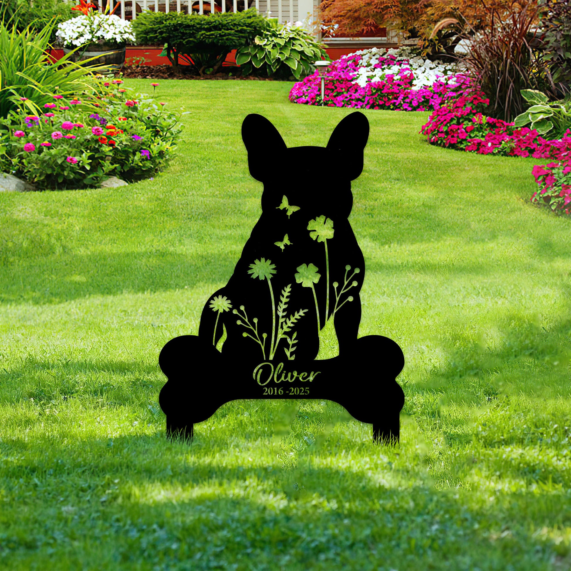 French Bulldog memorial garden sign displayed among flowers and lawn landscaping as an outdoor pet tribute