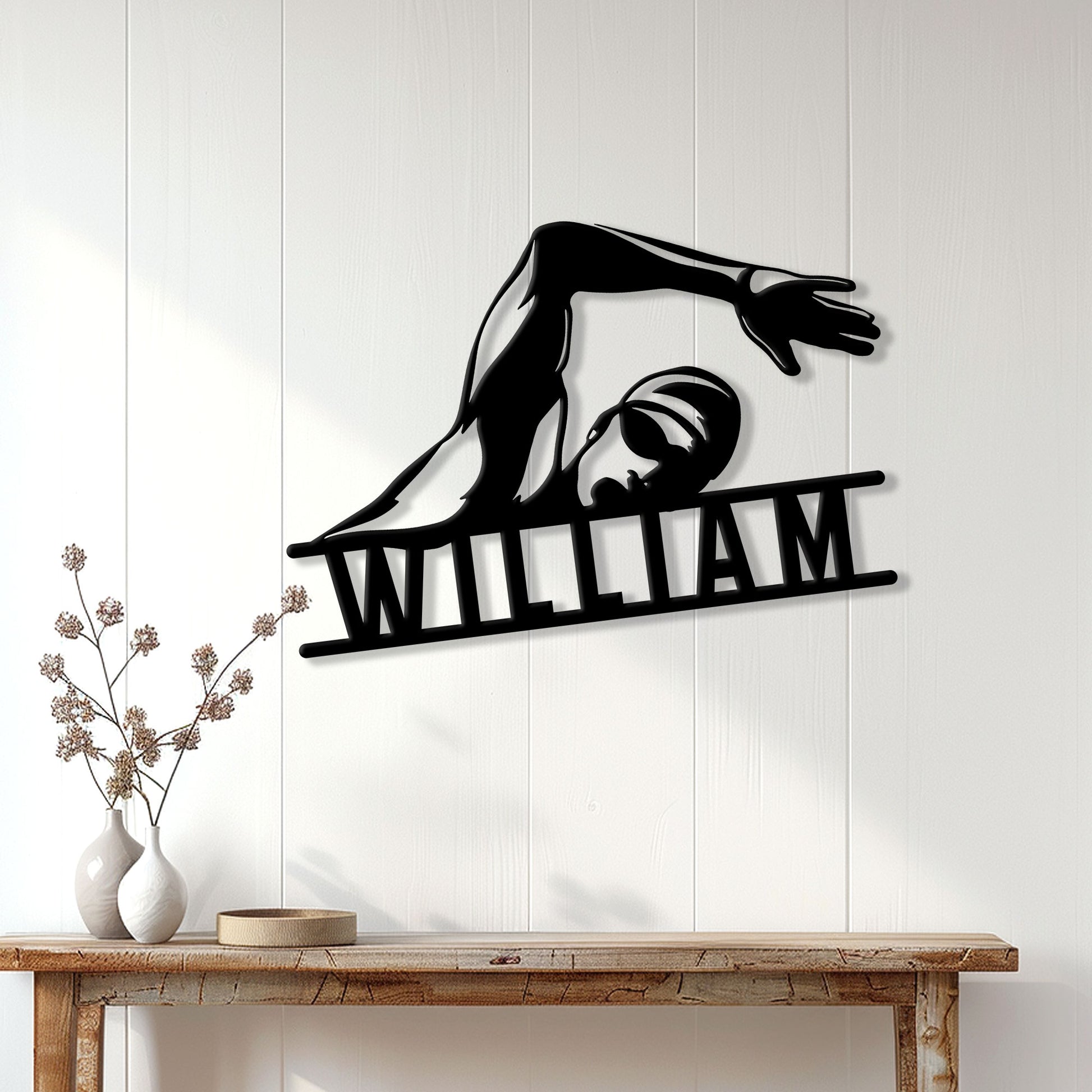 Freestyle swimming silhouette wall sign displayed above a console table in a bright home interior