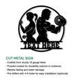 Black fitness wall sign showcasing a woman and man strength training with weights